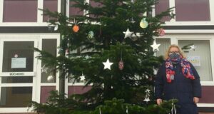 Maschens Ortsbürgermeisterin Angelika Tumuschat Bruhn vor dem von Kindern geschmückten Weihnachtsbaum im Maschener Ortskern. Foto: Tumuschat-Bruhn