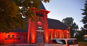 Die Kirche in Meckelfeld leuchtete am Abend in einem roten Farbton um auf die Situation in der Veranstaltungsbranche aufmerksam zu machen. Foto: Hamann
