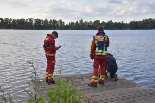 DLRG-Retter suchen vom Steg aus mittels Unterwasser-Drohne nach dem im Hörstener See vermissten Dummy. Foto: Hamann