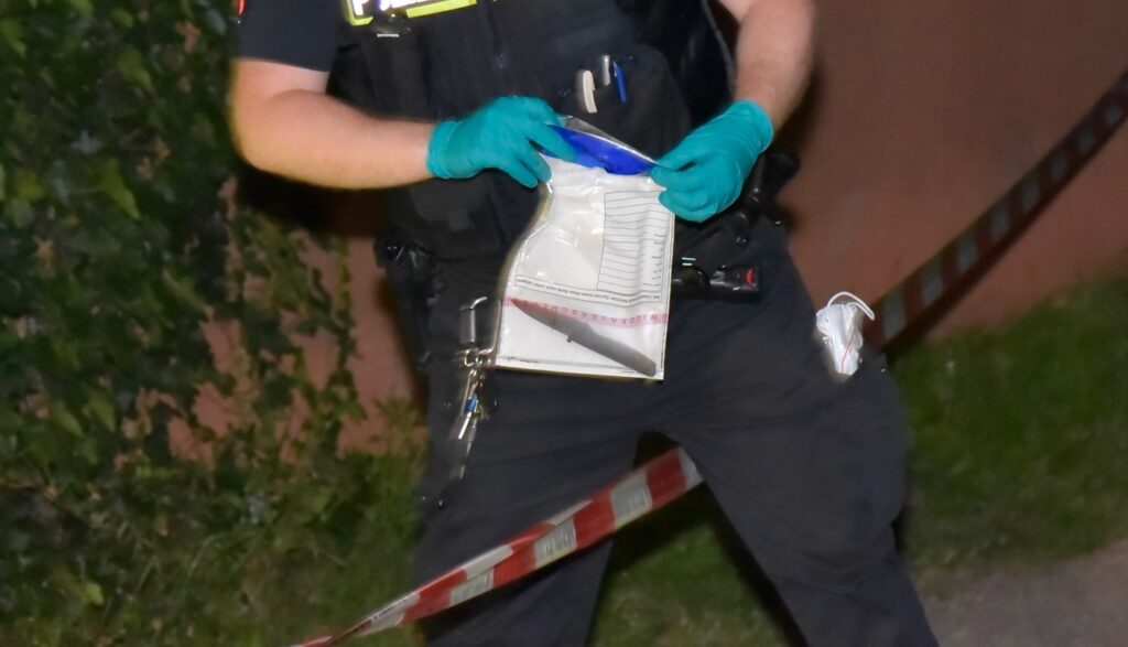 Die mutmaßliche Tatwaffe ist von einem Polizisten in einer Tüte gesichert worden. Foto: JOTO