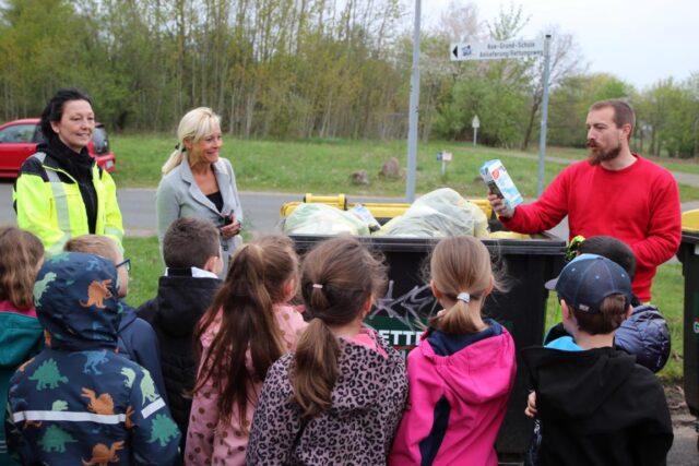 Vicky Scheer und Tom Stroth erläutern den Mädchen und Jungen die Bedeutung von richtiger Mülltrennung und Recycling. Foto: Landkreis Harburg