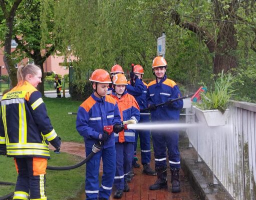 Mitglieder der Jugendfeuerwehr reinigen das Geländer am Schulteich in Meckelfeld. Foto: Feuerwehr