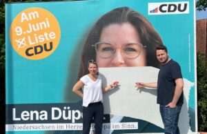 Jennifer Schrader und Markus Warnke von der CDU stehen vor einem zerstörten Wahlplakat in Hittfeld. Foto: ein