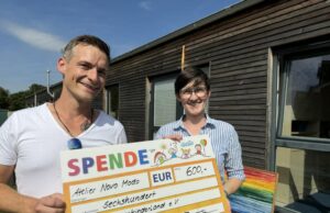 Künstler Birger Timm übergibt seine Spende an Annkatrin Schwarz, Leitung Regenbogenkinderland e.V. Foto: Gemeinde Seevetal