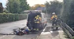 Feuerwehrleute löschen den brennenden Transporter im Bültenweg in Fleestedt. Foto: Sievers