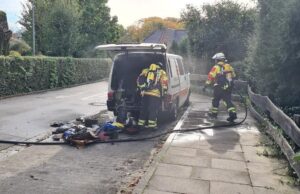 Feuerwehrleute löschen den brennenden Transporter im Bültenweg in Fleestedt. Foto: Sievers