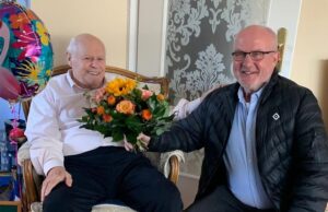 Der Meckelfelder Ortsbürgermeister Peter Langenbeck überreicht einen Blumenstrauß zum Geburtstag. Foto: Langenbeck